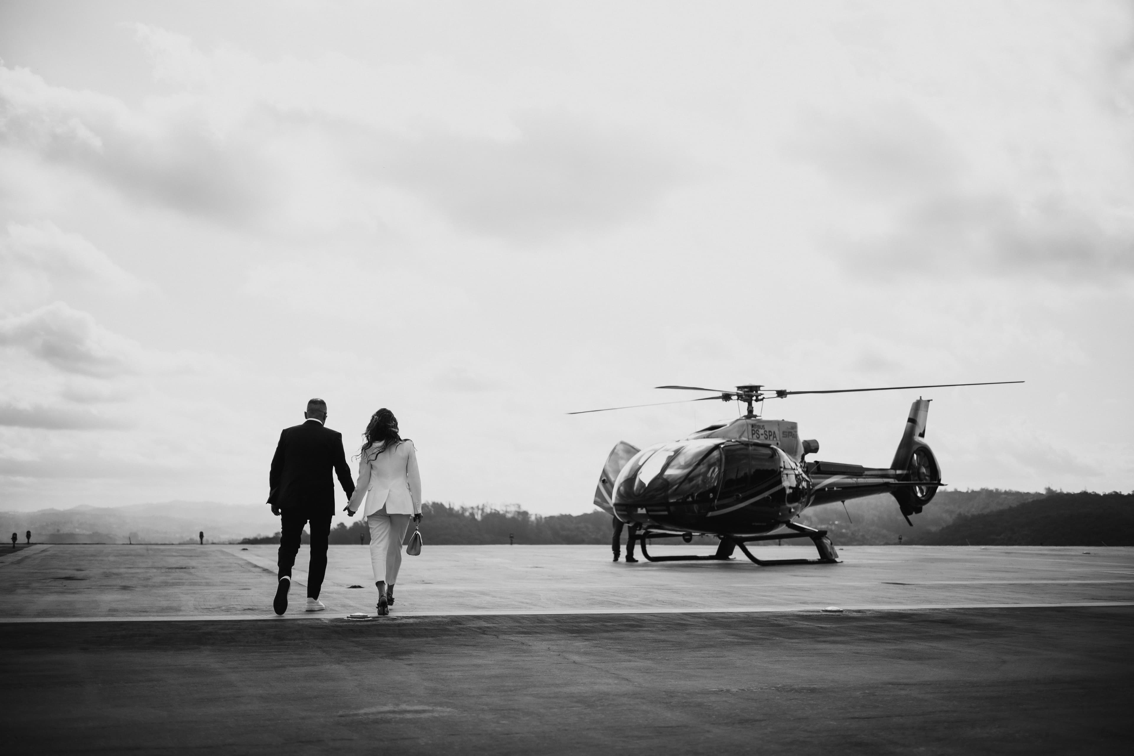 Casal caminhando em direção ao helicóptero